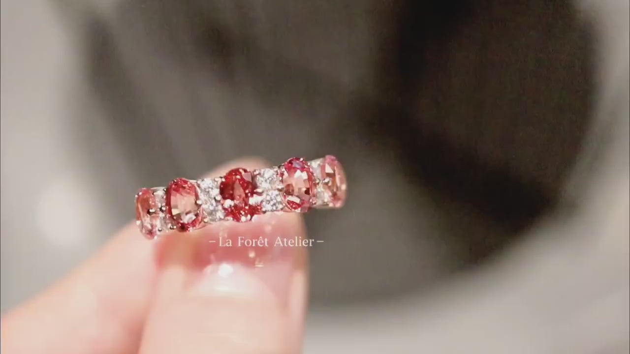 Pink-orange gemstone ring with alternating white stones

