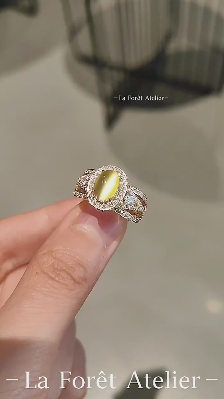 Gold ring with oval lab-grown chrysoberyl cat’s eye and diamond halo








