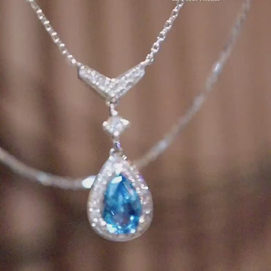 Teardrop aquamarine pendant in halo diamond setting with white gold chain








