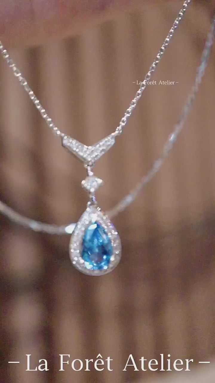 Teardrop aquamarine pendant in halo diamond setting with white gold chain








