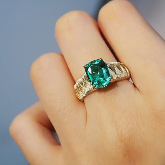 The Emerelle ring features a radiant 2ct lab grown emerald on a textured quilted gold band—a bold, elegant statement of timeless design.

